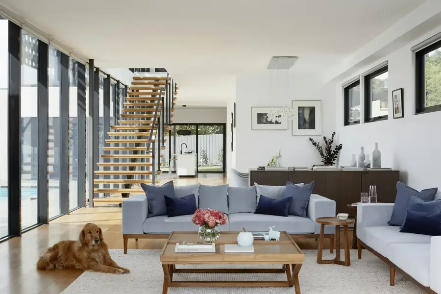 An open-plan interior with tall windows and a staircase