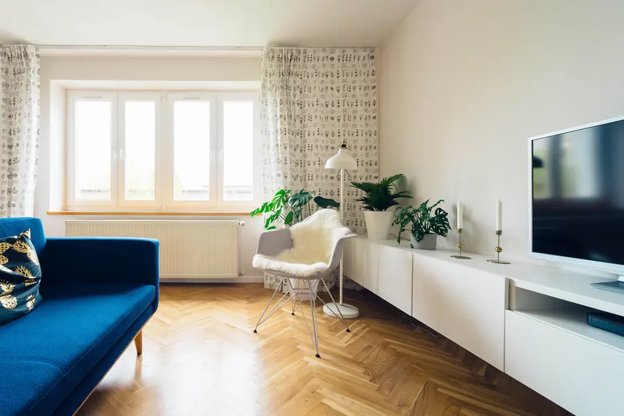 A room with a wide multi-pane window above a seating area